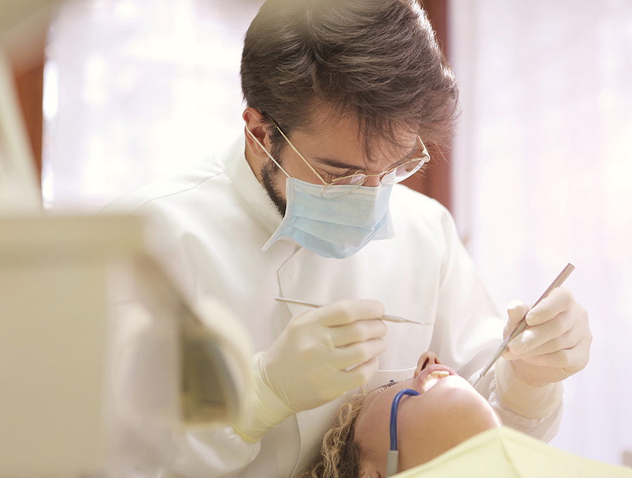 Un dentista revisa bien a fondo los dientes de su paciente.