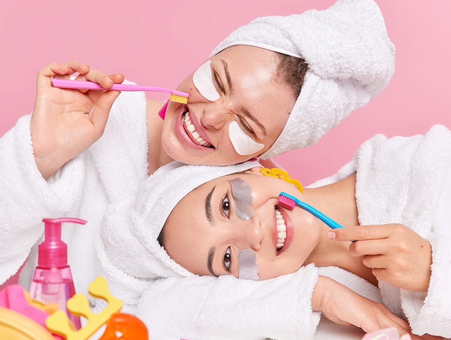 Dos amigas se limpian los dientes en su ritual de belleza femenina.