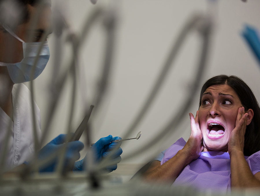 Mujer parece estar asustada en la consulta del dentista antes de la intervención.