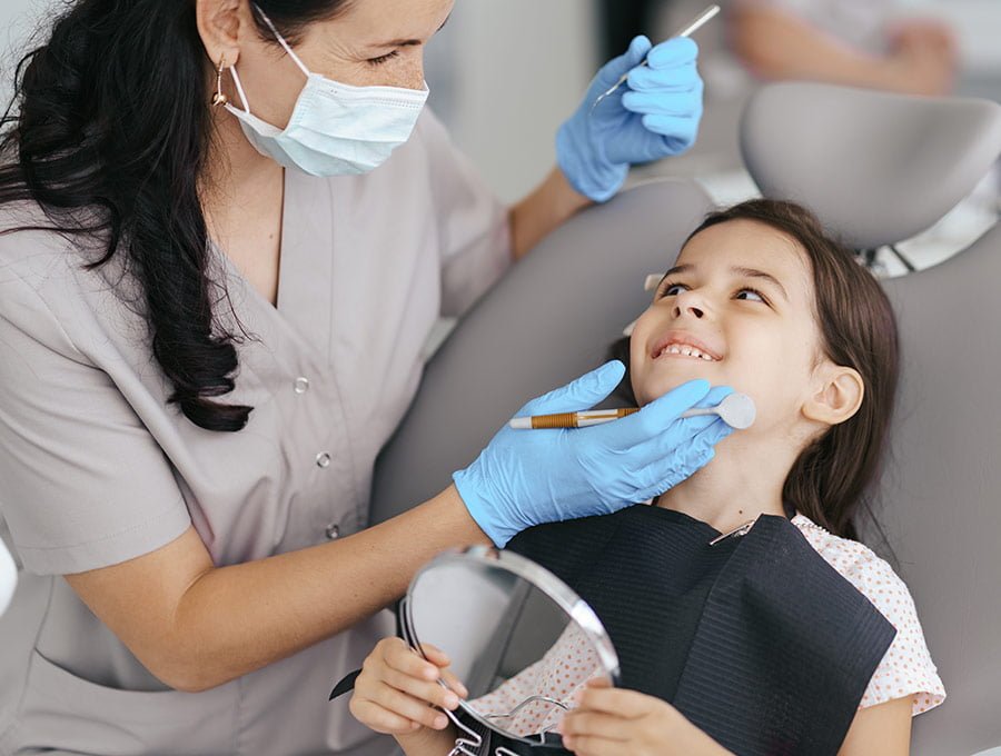 Esta niña pequeña está contenta de estar en la consulta del dentista.