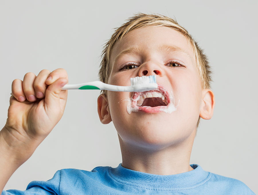 Este niño ha aprendido a cepillarse los dientes con pasta dental fluorada.
