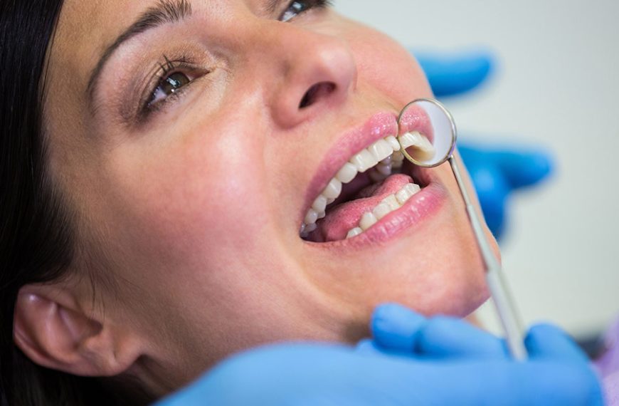 Dentista revisa los dientes de una paciente tras el blanqueamiento dental.