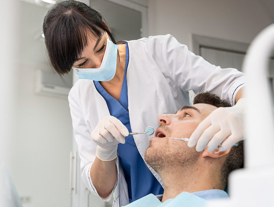 Dentista revisa cuidadosamente los dientes de un paciente.