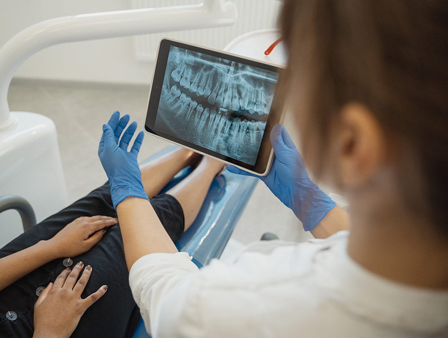 La dentista muestra al paciente la radiografía dental de sus dientes.