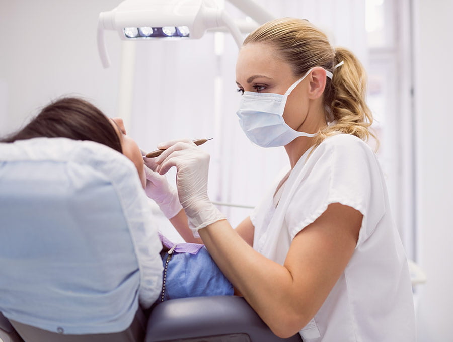 Dentista realiza una limpieza dental antes del blanqueamiento.