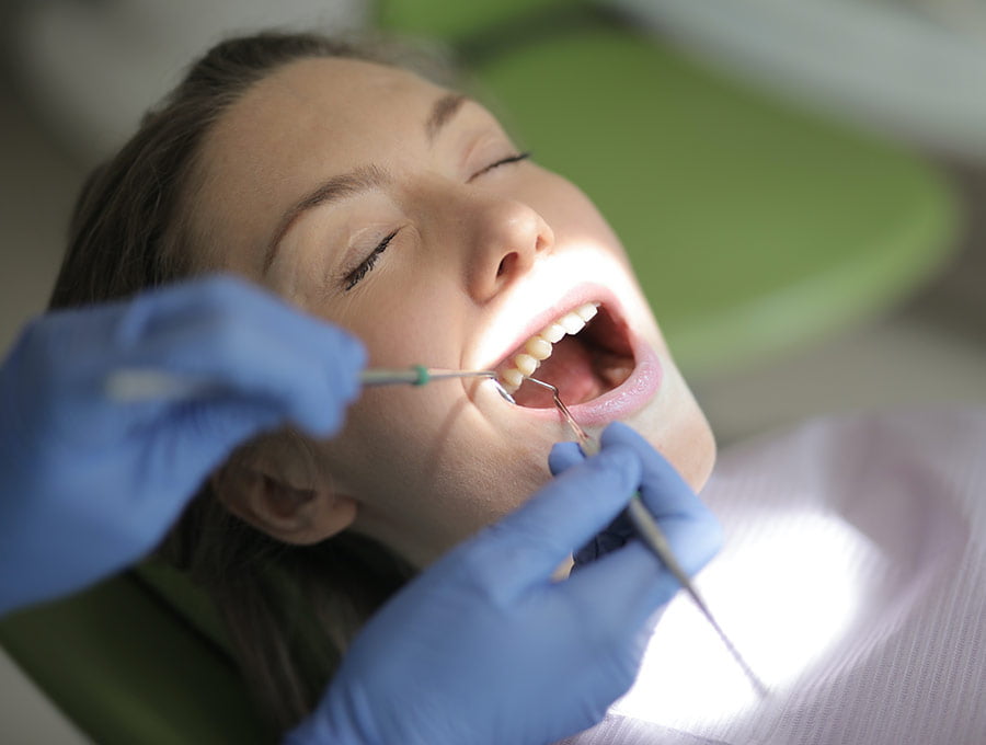 Dentista revisa el implante dental de una paciente y parece que está todo correcto.