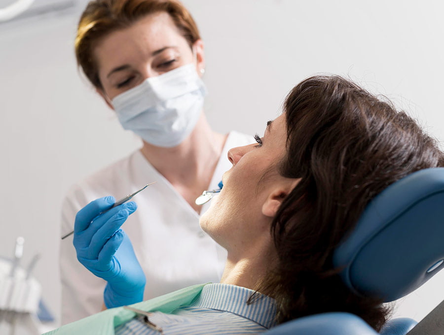 La mujer tiene la boca abierta en la consulta del dentista.