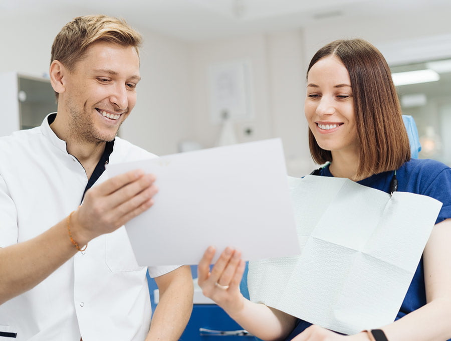 Dos profesionales odontólogos revisando los datos de un paciente.